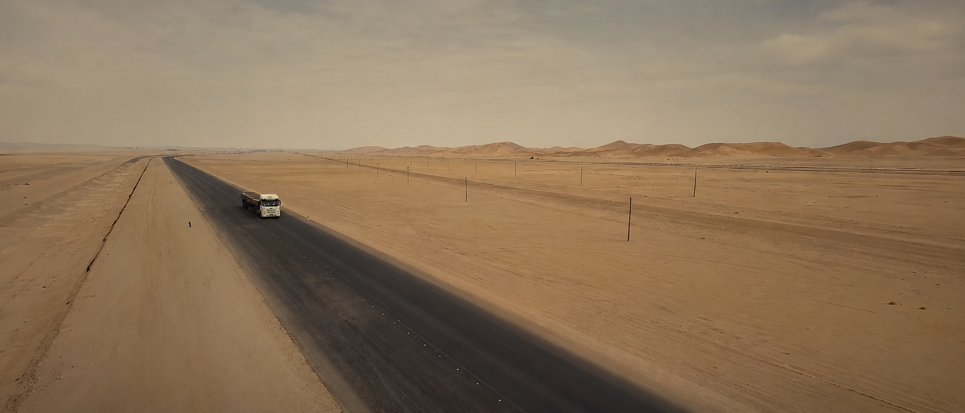 Truck moving along a Namib road, restored from real client road footage.